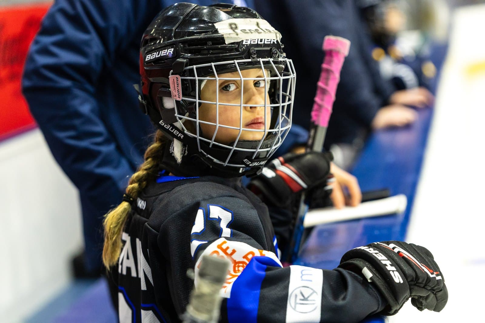 Close portrait of a player at the bench door, gloves on the rail