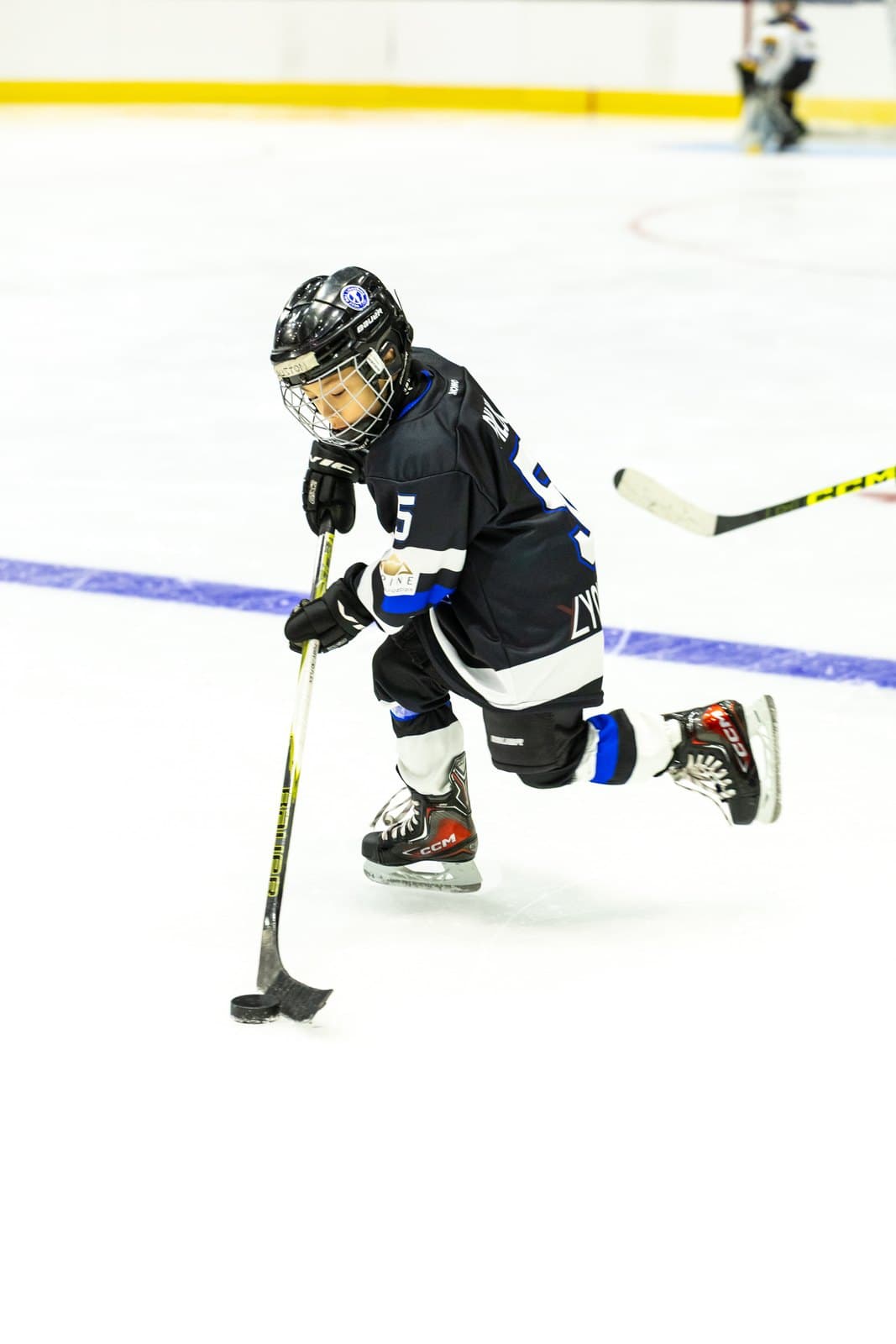 A skater chases a loose puck into the corner