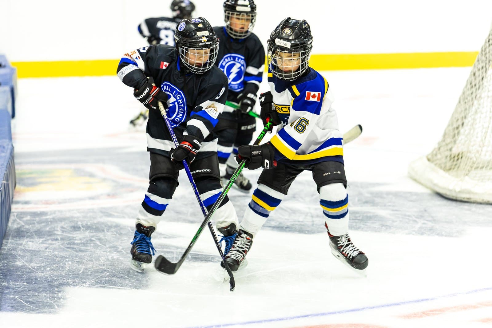 A pack of skaters chases the puck up the ice, legs churning