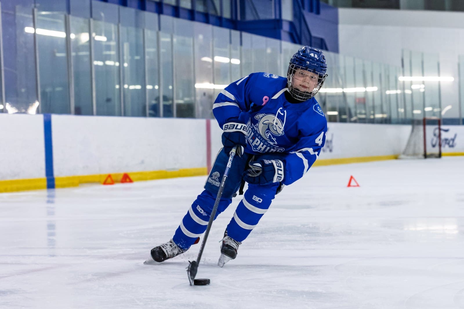 A player cuts across the blue line with the puck under control
