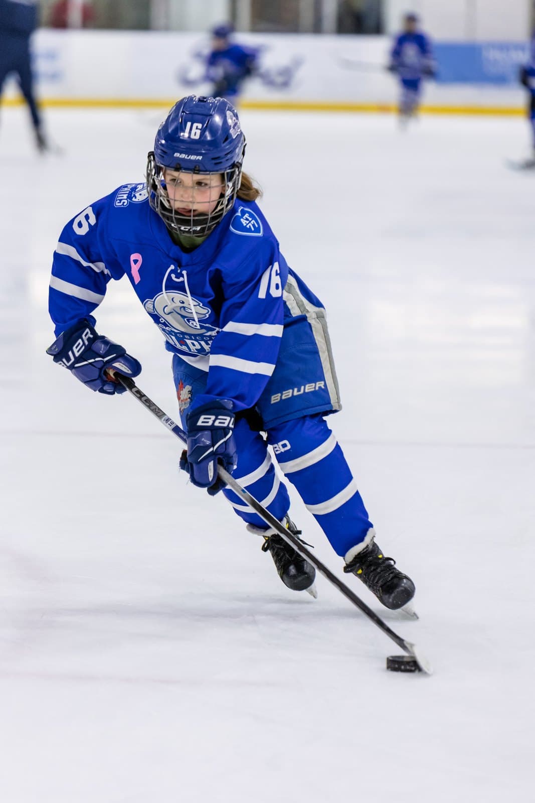 A skater drives through the neutral zone with the puck on the forehand