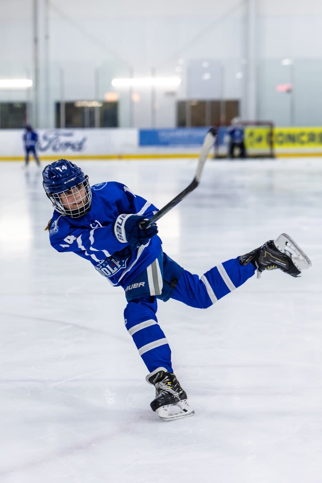 A skater at full extension mid-stride, the puck out in front