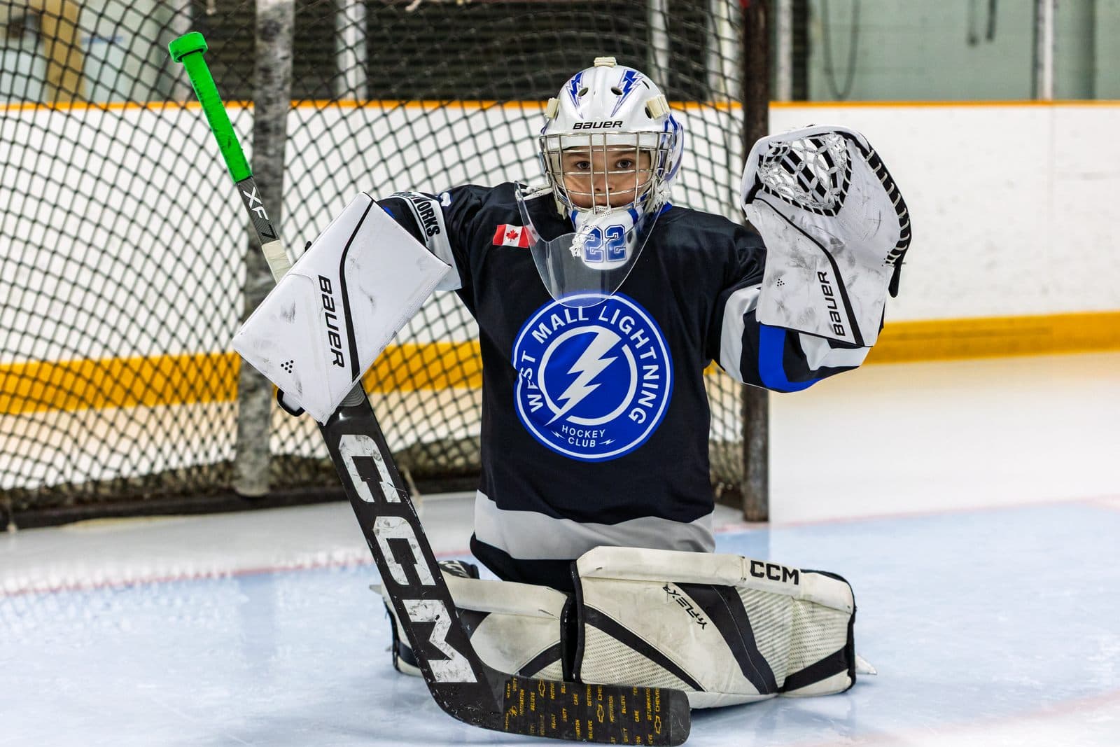 A goaltender set in the crease, glove open, tracking the play