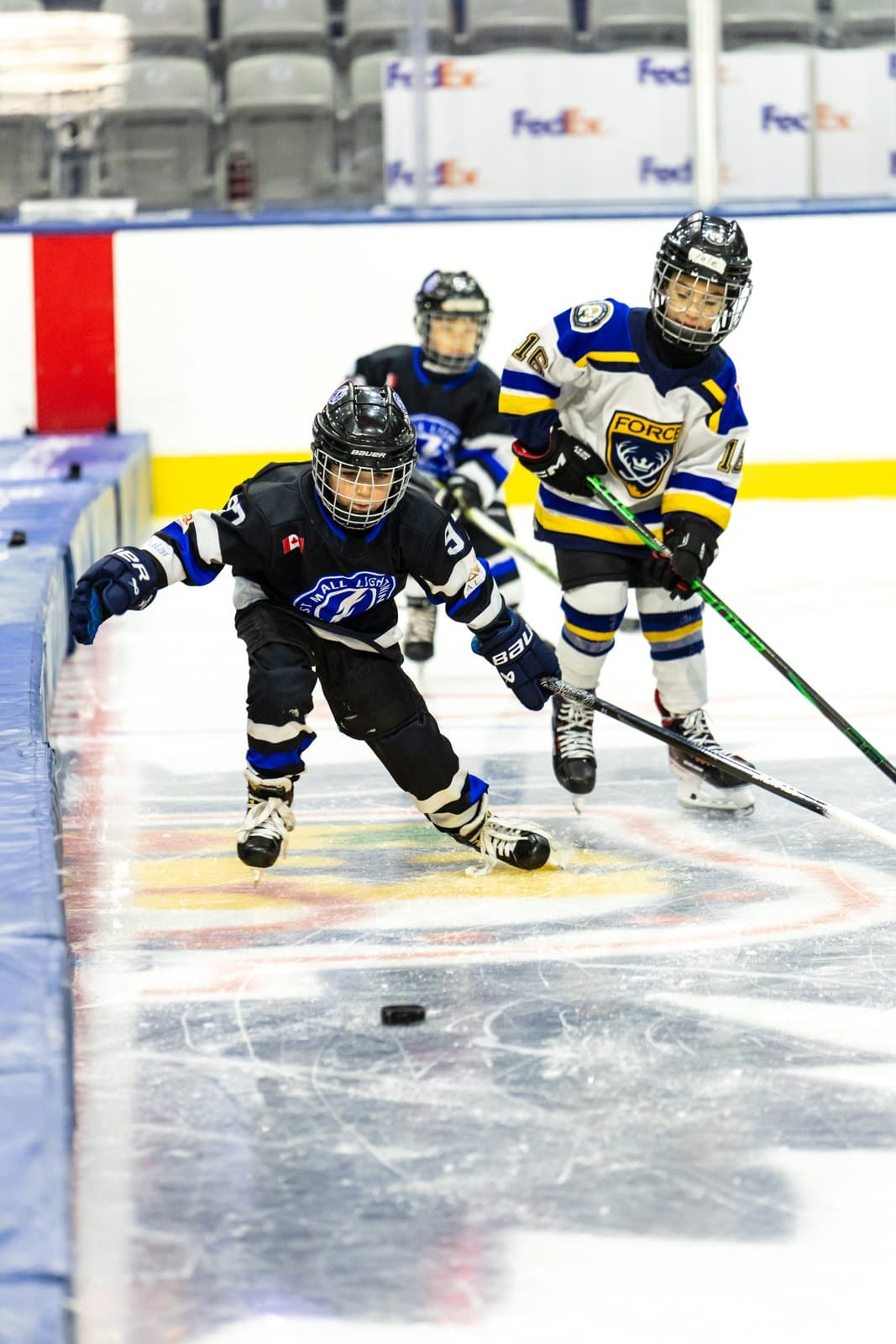 Skaters converge on a loose puck behind the net