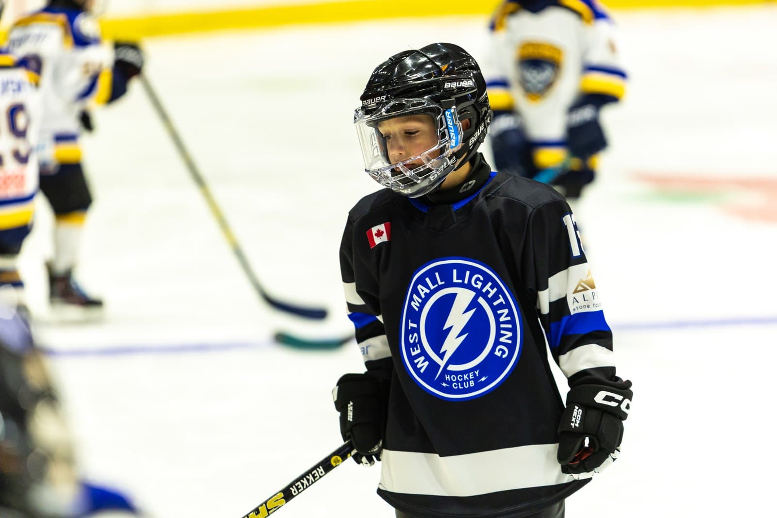 Close portrait of a skater pausing mid-ice, stick across the body