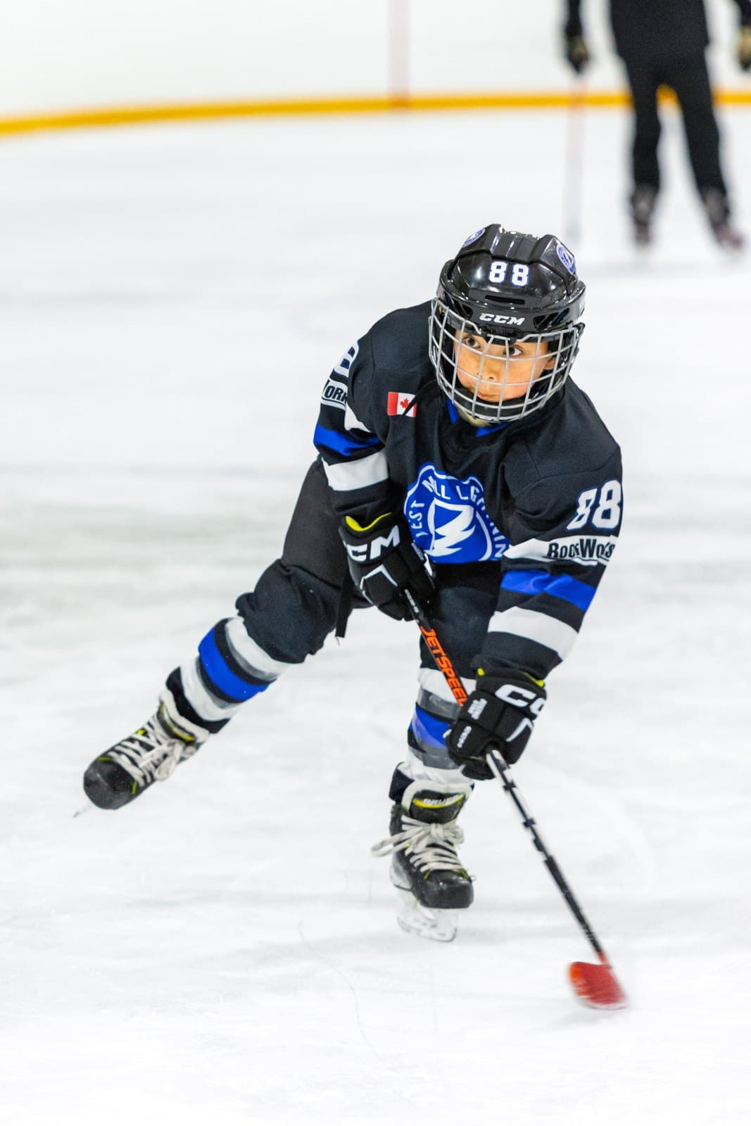 A skater pushes the pace up ice with the puck ahead of the blade