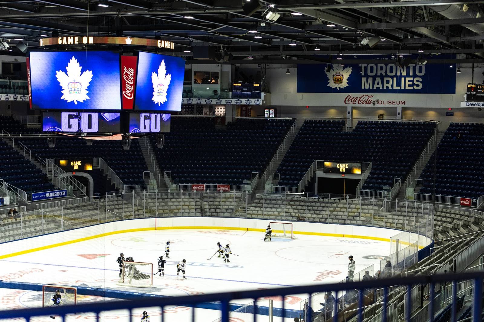 Wide view of the arena bowl, empty seats rising above the ice