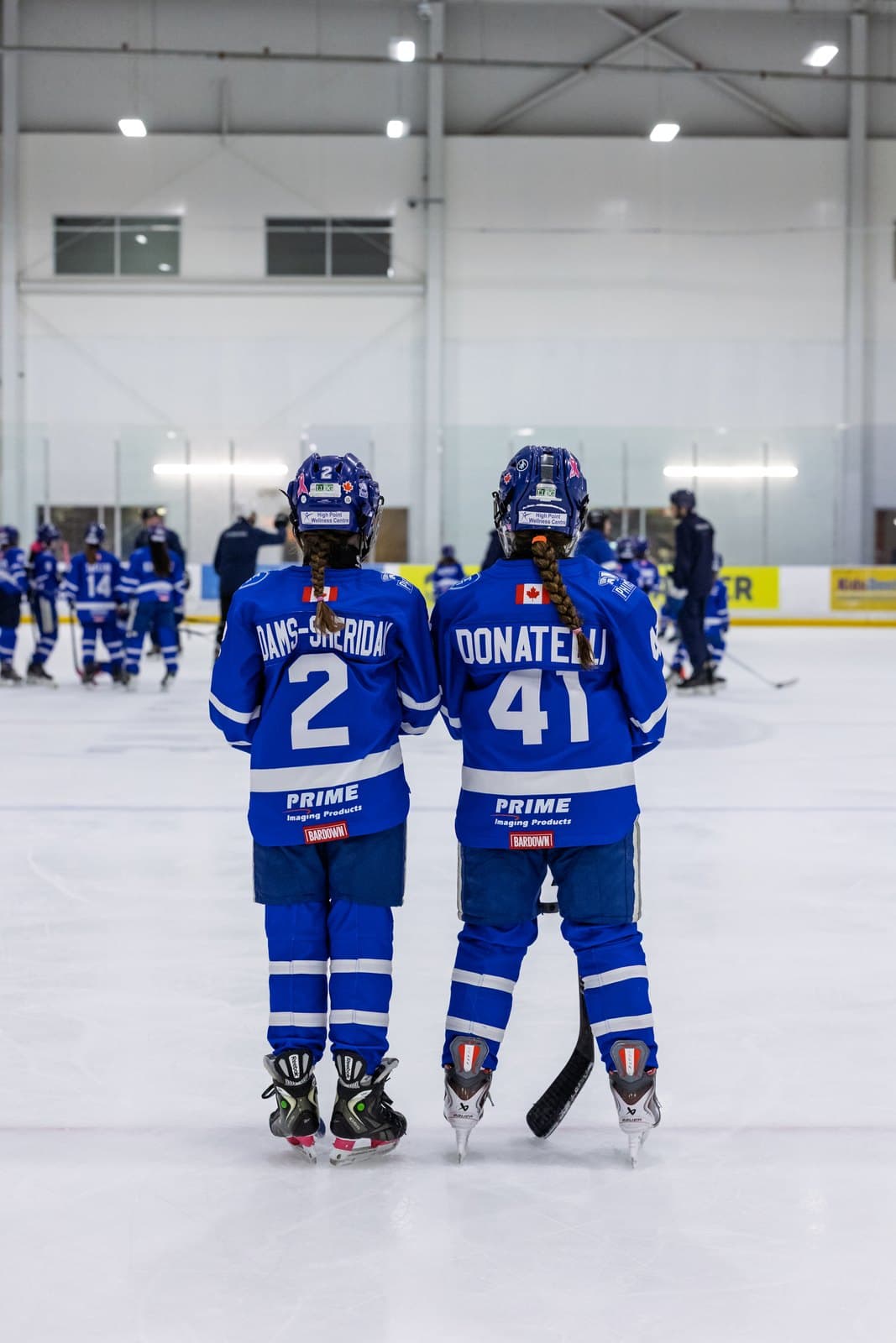 Two teammates stand side by side, jersey numbers facing the camera